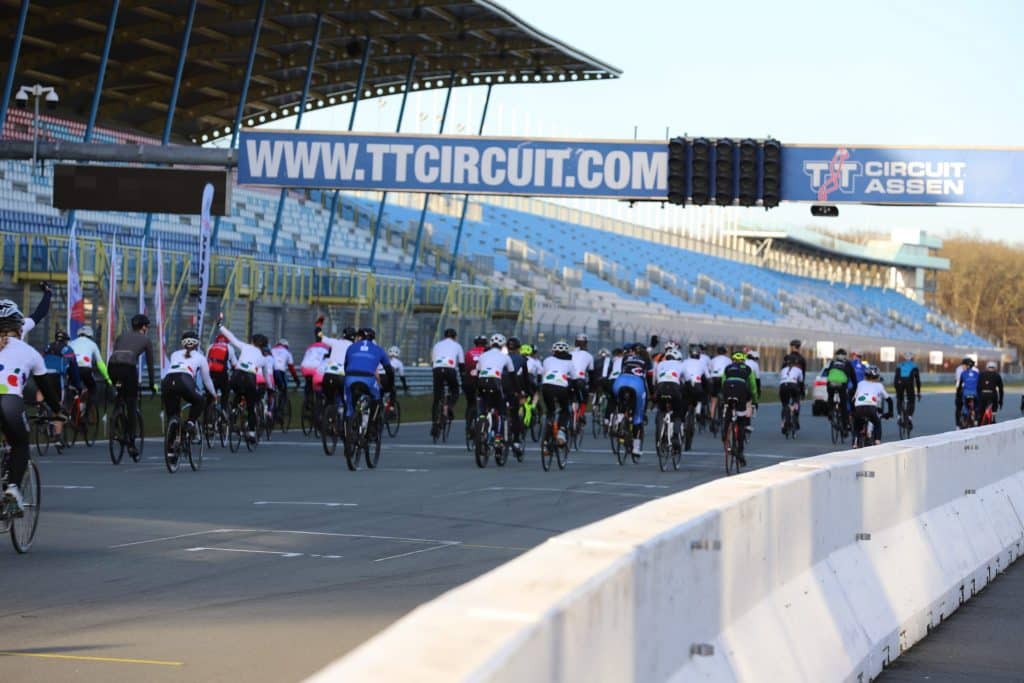 Deelnemers van Team Assen fietsen over het TT Circuit in Assen